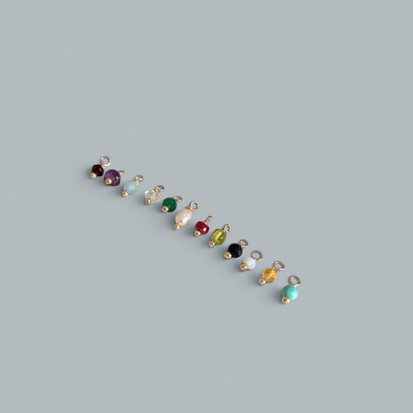 TSJ assorted gemstone and pearl charms with gold accents. Includes amethyst, aquamarine, pearl, ruby, emerald, and turquoise.