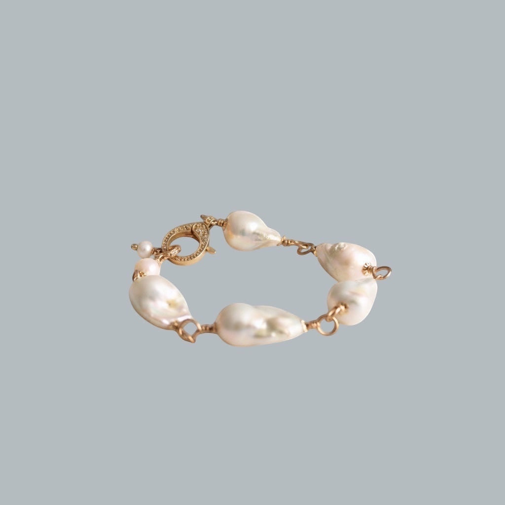 TSJ baroque pearl charm bracelet with gold-tone wire and cubic zirconia clasp. Unique irregular pearls with iridescent sheen.