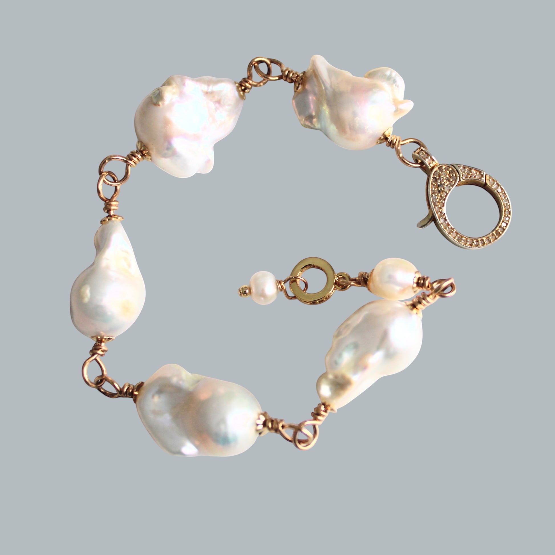 TSJ baroque pearl bracelet with gold-tone wire and cubic zirconia clasp. Unique, iridescent pearls.