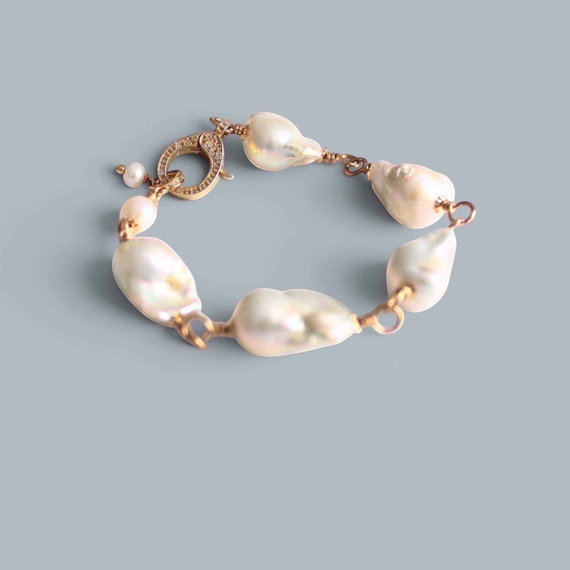 TSJ baroque pearl bracelet with gold-tone wire and cubic zirconia clasp. Unique, iridescent pearls.