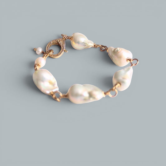 TSJ baroque pearl bracelet with gold-tone wire and cubic zirconia clasp. Unique, iridescent pearls.