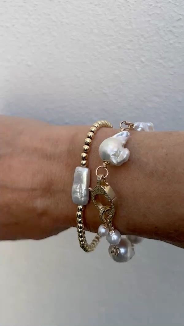 TSJ gold-tone bracelet with baroque pearls and cubic zirconia clasp. Features irregular white pearls and gold beads.